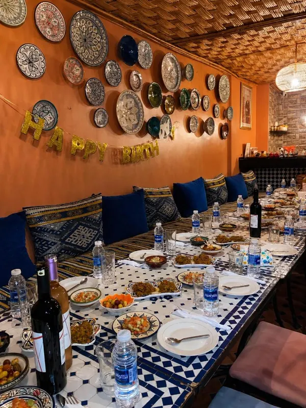 Une longue table dressée sous le mur d’assiettes peintes