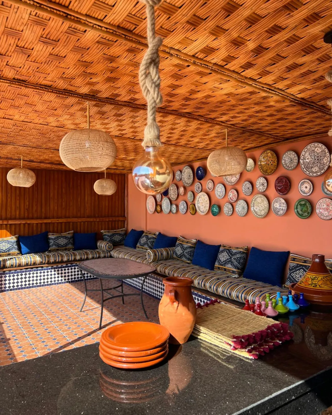 Le salon sur le toit, sa table et le mur d’assiettes