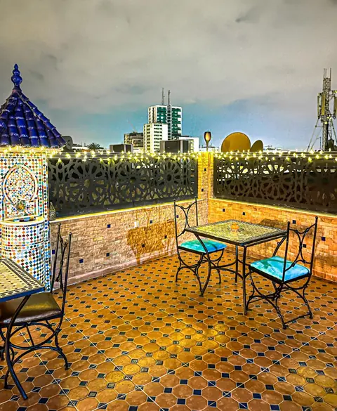La terrasse sur le toit, tables de fer forgé et fontaine de zellige