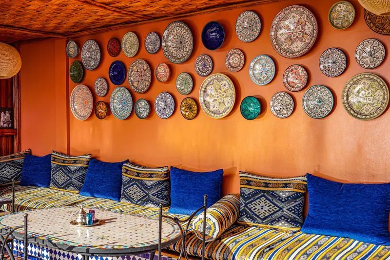 Le salon sur le toit, ses assiettes peintes et ses coussins bleus